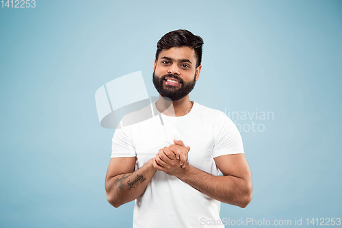 Image of Half-length close up portrait of young man on blue background.