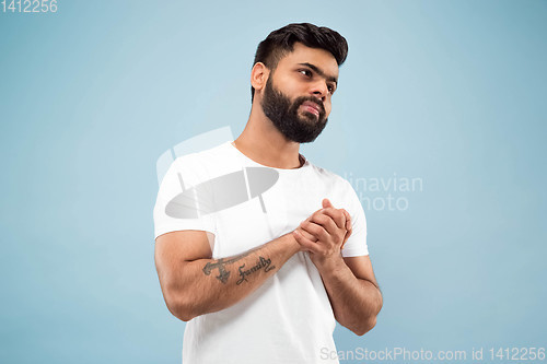 Image of Half-length close up portrait of young man on blue background.