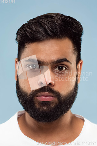 Image of Close up portrait of young man on blue background.
