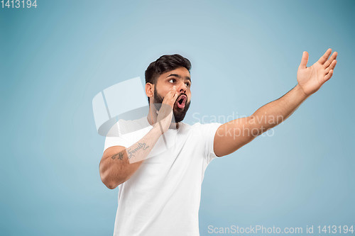 Image of Half-length close up portrait of young man on blue background.