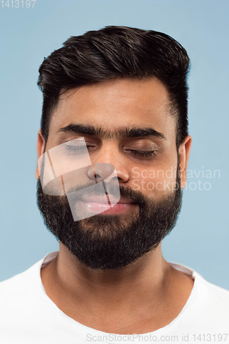 Image of Close up portrait of young man on blue background.