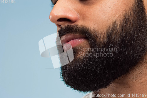 Image of Close up portrait of young man on blue background.