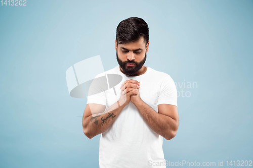 Image of Half-length close up portrait of young man on blue background.