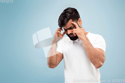 Image of Half-length close up portrait of young man on blue background.