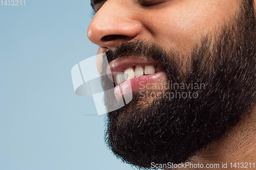 Image of Close up portrait of young man on blue background.