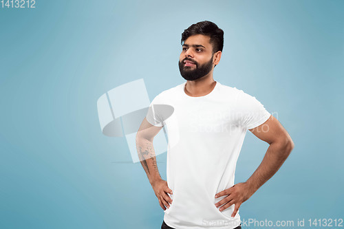 Image of Half-length close up portrait of young man on blue background.