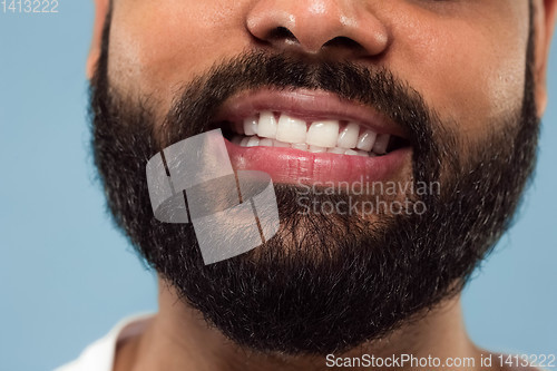 Image of Close up portrait of young man on blue background.