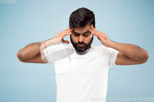 Image of Half-length close up portrait of young man on blue background.