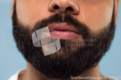 Image of Close up portrait of young man on blue background.