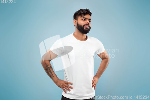 Image of Half-length close up portrait of young man on blue background.