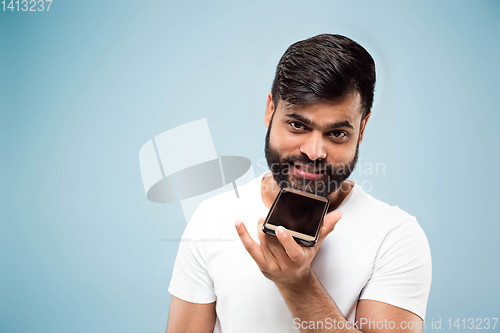 Image of Half-length close up portrait of young man on blue background.