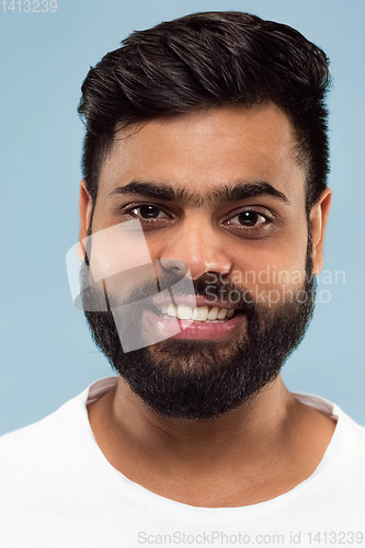 Image of Close up portrait of young man on blue background.
