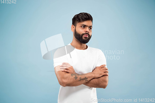 Image of Half-length close up portrait of young man on blue background.