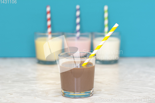 Image of Chocolate milkshake in front of a row of flavoured milkshakes