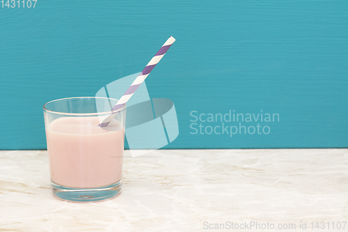 Image of Delicious strawberry milkshake with a straw in a glass