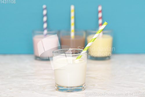 Image of Fresh milk in front of a row of flavoured milkshakes