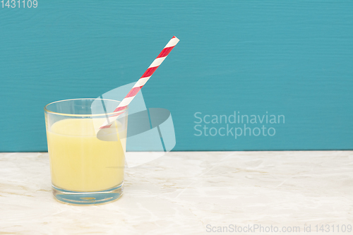 Image of Tasty banana milkshake with a straw in a glass 