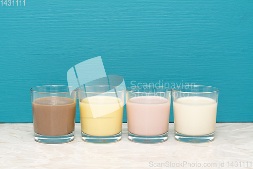 Image of Chocolate, banana and strawberry milkshakes and milk in tumblers