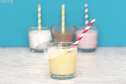 Image of Banana milkshake in front of a row of flavoured milkshakes