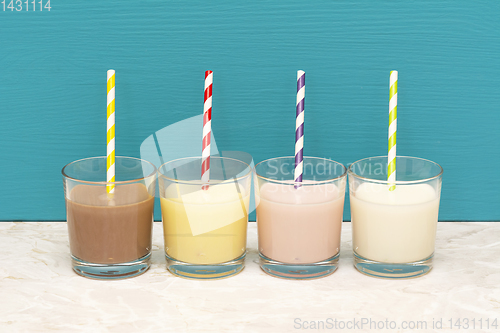 Image of Milkshakes and fresh milk with retro paper straws in glass tumbl