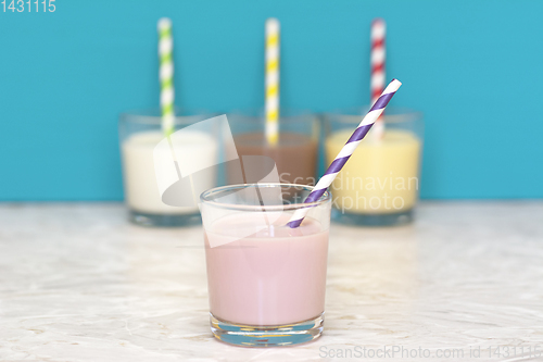 Image of Strawberry milkshake in front of a row of flavoured milkshakes