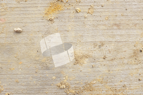 Image of Smooth wooden board background, covered with crumbled earth and 