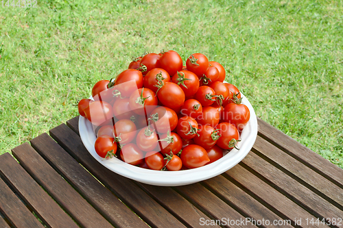 Image of Pile of juicy fresh cherry tomatoes in a white dish