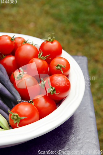 Image of Ripe red tomatoes in a white serving dish