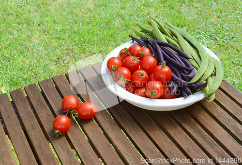 Image of Red tomatoes with green and purple beans in a dish