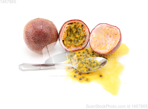Image of Whole and halved passion fruits ready to eat with a spoon