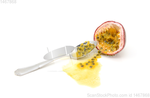 Image of Scooping out pulp from half a passion fruit with a spoon
