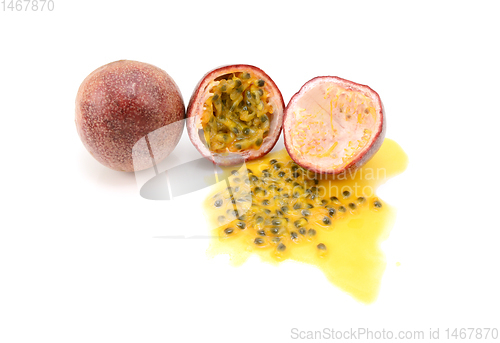 Image of Whole and halved passion fruits with spilled juice and seeds