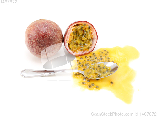 Image of Whole passion fruit and half-eaten cross section with spoon
