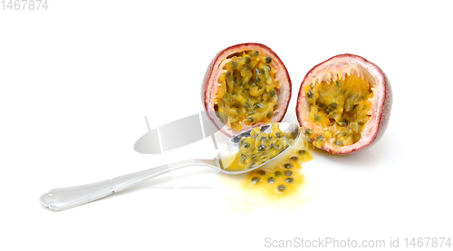 Image of Spoon scooping out pulp and seeds from a passion fruit 