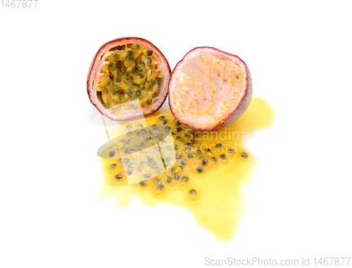 Image of Half passion fruit with sweet pulp, seeds and juice spilled 