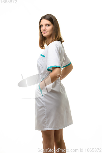 Image of Girl in a white medical gown turned and looked into the frame, isolated on white background