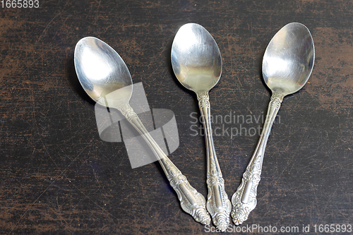 Image of There are three tablespoons on the old table