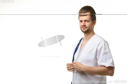 Image of Doctor fastening buttons on medical shirt isolated on white background