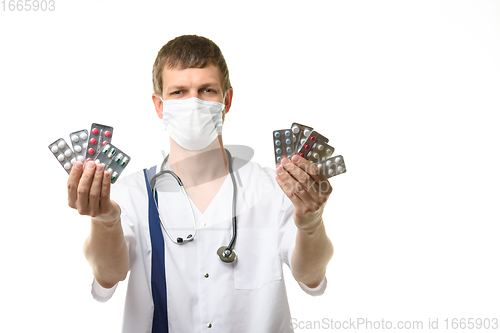 Image of Doctor stretches out his hands with medications into the frame