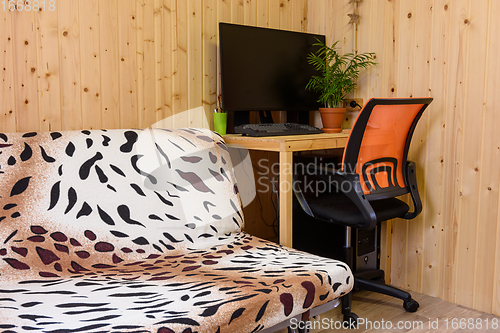 Image of A fragment of the interior of a country house room, next to the sofa is a computer desk