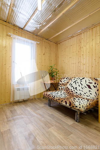 Image of Country house room interior, sofa, small table and white tulle curtained window