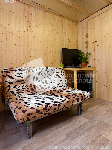 Image of Fragment of the interior of a small living space, in the corner there is a computer table, next to a sofa