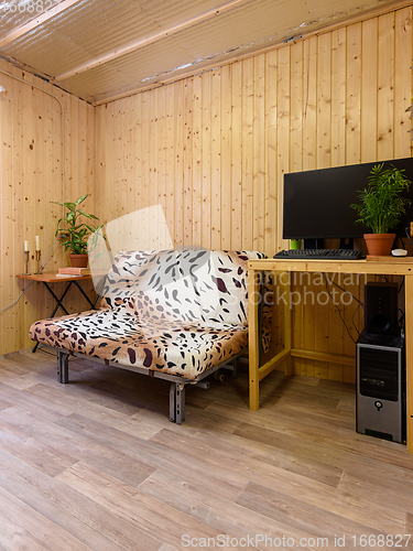 Image of Interior of a country house room, next to the sofa is a computer desk