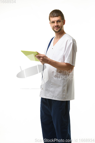 Image of The doctor examines the patient\'s analyzes in the tablet and happily looks into the frame