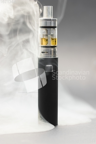 Image of Electronic cigarette against background full of smoke