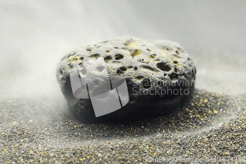 Image of Smoke whirling around small meteorite stone