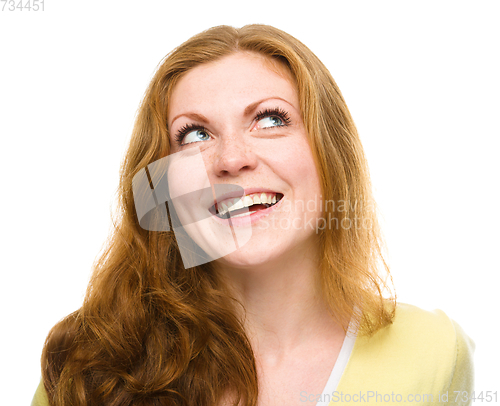 Image of Young happy woman is looking up and smile