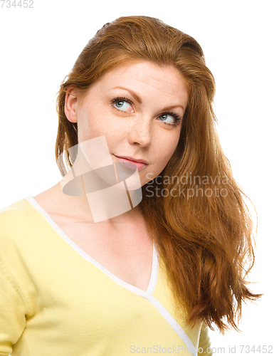 Image of Young happy woman is looking up and smile