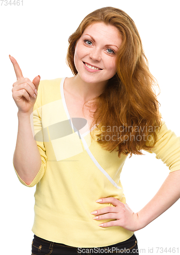 Image of Portrait of a young woman pointing to the left