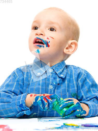 Image of Little boy is playing with paints